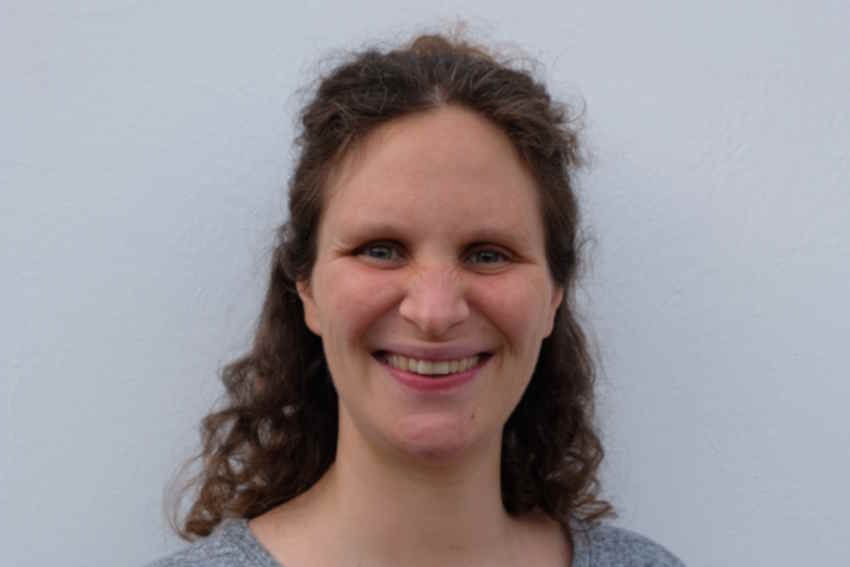 Portraitfoto von einer weissen Frau mit lockigen braunen langen Haaren
